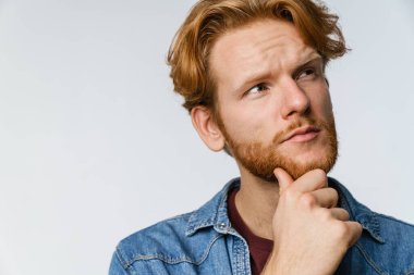 Yakışıklı zencefilin beyaz arka planda poz verip yukarı baktığını düşünüyor.