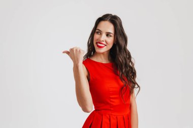 Mutlu güzel kız gülümsüyor ve pembe arka planda izole edilmiş parmakları gösteriyor.