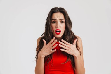 Korkmuş, kırmızı elbiseli güzel bir kız beyaz arka planda mahsur kalmış kameraya sürpriz yapıyor.