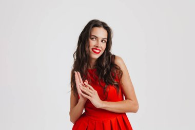 Mutlu güzel esmer kız gülümsüyor ve pembe arka planda soyutlanmış bir kenara bakıyor.