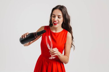 Beyaz arka planda izole edilmiş şampanya içerken gülümseyen güzel esmer kız.