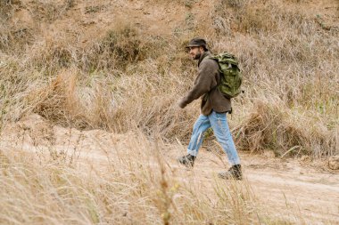 Sırt çantasıyla gezen ciddi yakışıklı bir adam.