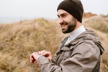 Mutlu yakışıklı adam gülümsüyor ve doğada çalışırken ukalalık yapıyor.