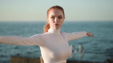 Ciddi bir genç kadının yakın çekim görüntüsü sabahleyin dışarıda yoga yapıyor.