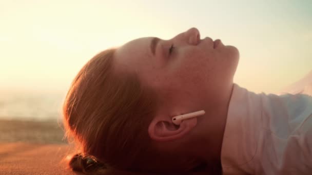 Eine Nahaufnahme Einer Schönen Jungen Frau Mit Ohrhörern Liegt Morgens — Stockvideo