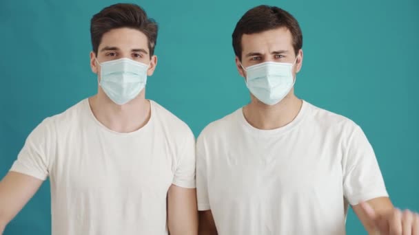 Zwei Ernsthafte Typen Mit Gesichtsmasken Machen Daumen Nach Unten Geste — Stockvideo