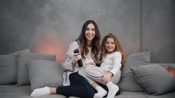 Gülümseyen Anne Kızı Evdeki Kanepede Otururken Televizyon Izliyorlar — Stok video