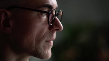 Odaklanmış bir iş adamının yakın plan görüntüsü, akşam ofiste oturan bilgisayarını kullanarak çalışıyor.