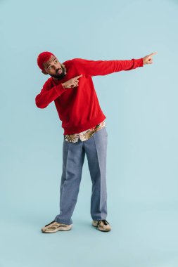 Şaşırmış Afro-Amerikalı adam mavi arka planda yalnız olduğunu söylüyor.