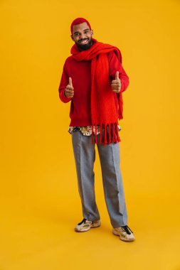 Neşeli Afrikalı Amerikalı adam gülümsüyor ve parmaklarını gösteriyor sarı arka planda izole bir şekilde.