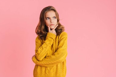 Şaşkın sarışın kız pembe arka planda izole edilmiş bir şekilde düşünüyor.