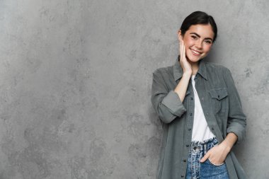 Sıradan giyinmiş mutlu bir kadının portresi izole edilmiş arka planda duruyor.