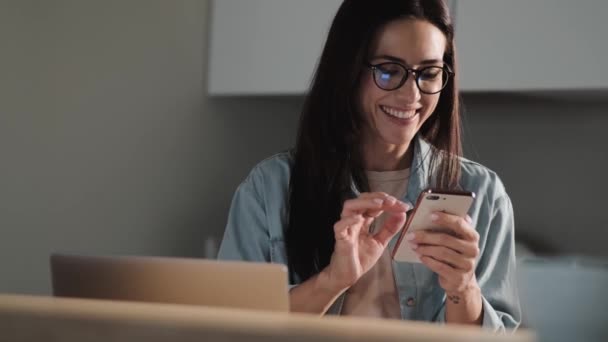 Щаслива Здивована Жінка Окулярах Використовує Свій Смартфон Сидячи Квартирах — стокове відео