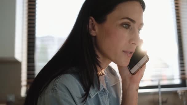 Una Donna Seria Sta Parlando Sul Suo Smartphone Mentre Usa — Video Stock