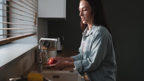 Uma Vista Lateral Uma Mulher Satisfeita Lavar Legumes Cozinha — Vídeo de Stock