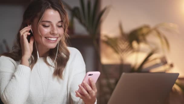 Pleased Positive Woman Using Earphones While Listening Music Sitting Table — Stock Video