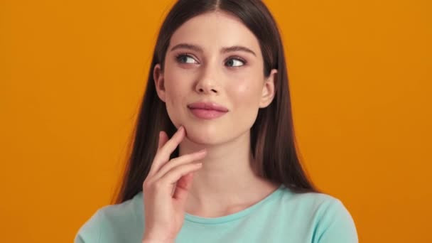 Myśląca Młoda Kobieta Pozuje Studio Pomarańczowym Tle — Wideo stockowe