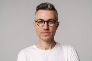 Gri arka planda izole edilmiş düşünceli bir adamın portresi.