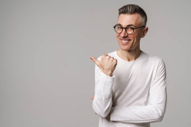 Gri arkaplanda izole edilmiş kopya alanı sunan heyecanlı yakışıklı adam