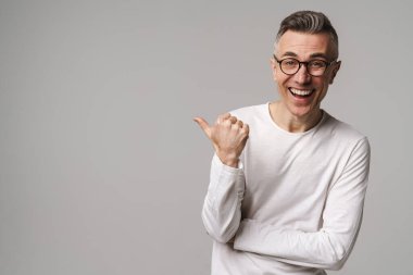 Gri arkaplanda izole edilmiş kopya alanı sunan heyecanlı genç adam