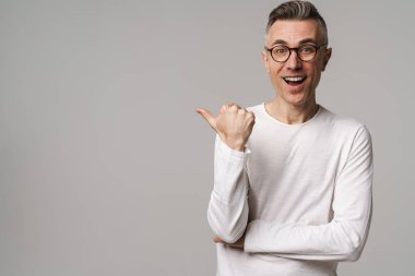 Gri arkaplanda izole edilmiş kopya alanı sunan heyecanlı yakışıklı adam