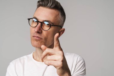 Gri arka planda izole edilmiş düşünceli bir adamın portresi.