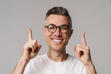 Gri arkaplanda izole edilmiş kopya alanı sunan heyecanlı yakışıklı adam