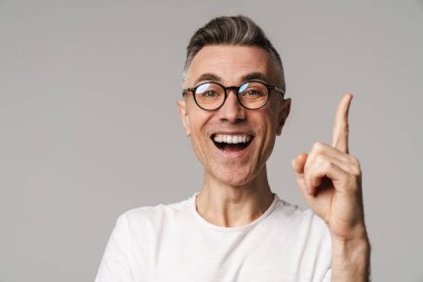 Gri arkaplanda izole edilmiş kopya alanı sunan heyecanlı yakışıklı adam