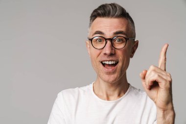 Gri arkaplanda izole edilmiş kopya alanı sunan heyecanlı yakışıklı adam