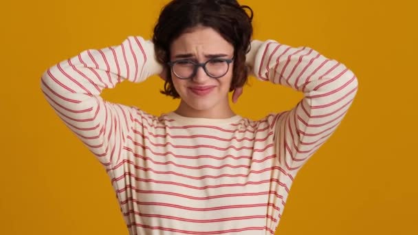 Una Joven Adolescente Disgustada Con Anteojos Cubre Las Orejas Mientras — Vídeo de stock