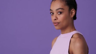 Güzel genç bir kadın kameraya poz veriyor. Stüdyoda Violet 'in arka planında izole bir şekilde duruyor.