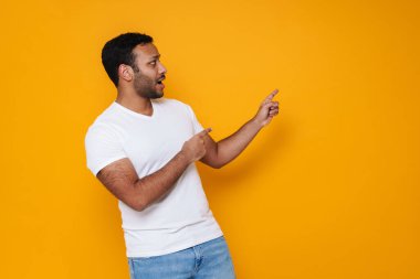 Asyalı genç, şaşırmış bir adam, sarı arka planda izole edilmiş...