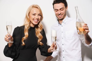 Beauitufl genç, şık giyimli Sevgililer Günü 'nü kutlayan beyaz arka planda izole edilmiş şampanya içen adam içki dolduruyor.