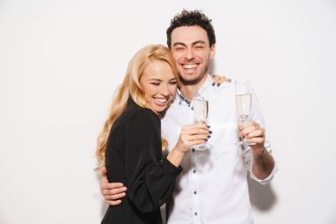 Beauitufl genç mutlu, şık giyimli sevgililer gününü kutlayan beyaz arka planda izole edilmiş şampanya içen çift.
