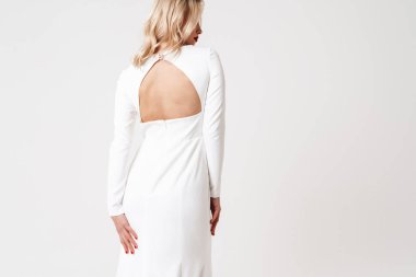 Beyaz arka planda soyutlanmış zarif elbiseli güzel sarışın kız.