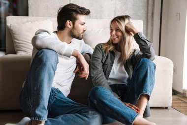 Mutlu genç çift evde otururken konuşuyor ve birbirlerine bakıyorlar.