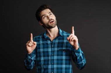 Yakışıklı adam gülümsüyor ve siyah arka planda kendini dışlanmış hissediyor.