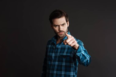 Siyah arka planda izole edilmiş kamerayı gösteren yakışıklı esmer adam.