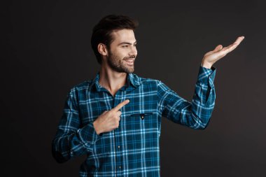 Siyah arka planda izole edilmiş telif alanını gösteren ve gülümseyen yakışıklı adam.