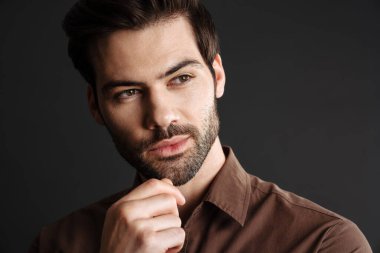 Esmer, yakışıklı, tıraşsız, poz veren, siyah arka planda yalnız gezen adam.