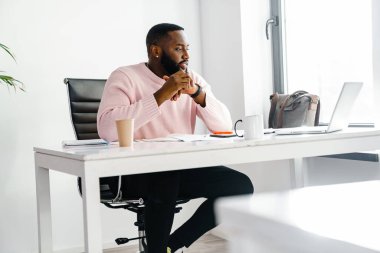 Ofis masasında otururken bilgisayarla video görüşmesi yapan yakışıklı bir iş adamı.