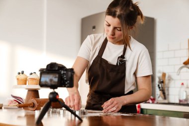 Odaklanmış fırıncı kadının ev mutfağında Noel kurabiyesi yaparken çekilmiş kamera görüntüleri.