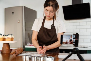 Ev mutfağında kurabiye yapan fırıncı kadının kamera görüntüleri.