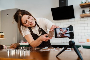 Mutlu fırıncı kadının ev mutfağında Noel kurabiyesi yaparken çekilmiş kamera görüntüleri.
