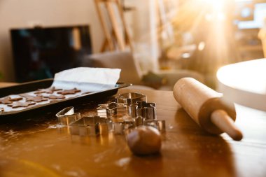 Noel kurabiyeleri ve merdane evdeki rahat, parlak mutfakta masanın üstünde duruyor.