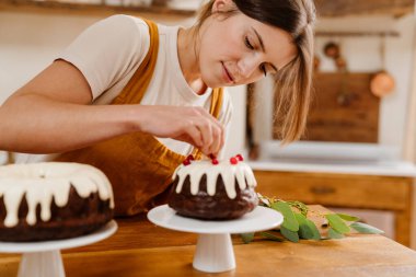 Kafkas odaklı pasta şefi kadın sıcak mutfakta çikolatalı pasta yapıyor.