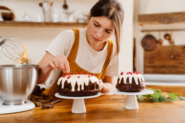 Kafkas odaklı pasta şefi kadın sıcak mutfakta çikolatalı pasta yapıyor.