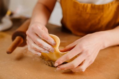 Kafkasyalı pasta şefi kadın rahat mutfakta tart yapıyor.