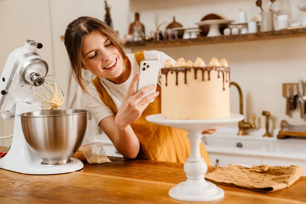 Güzel Mutlu Pasta Şefi Kadın Rahat Bir Mutfakta Cep Telefonuyla — Stok fotoğraf