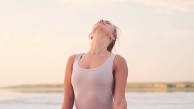 A pleased woman is doing meditation sitting outside on nature